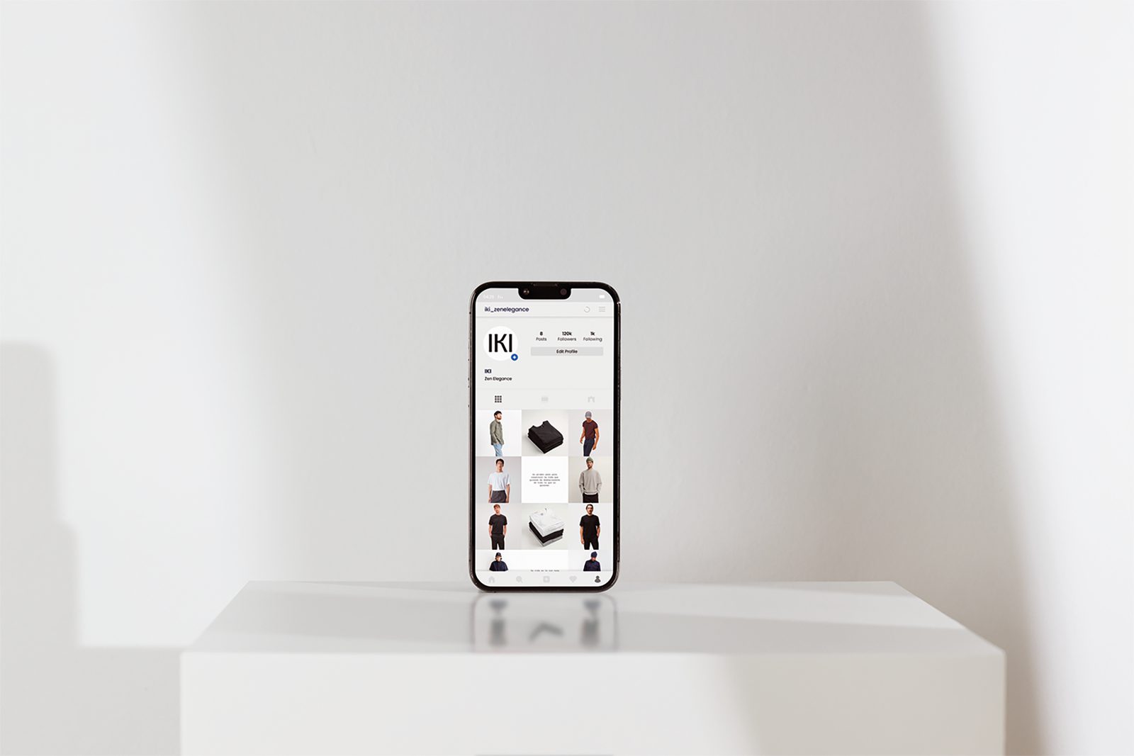 Móvil sobre un pedestal blanco con la rejilla del perfil de Instagram de IKI