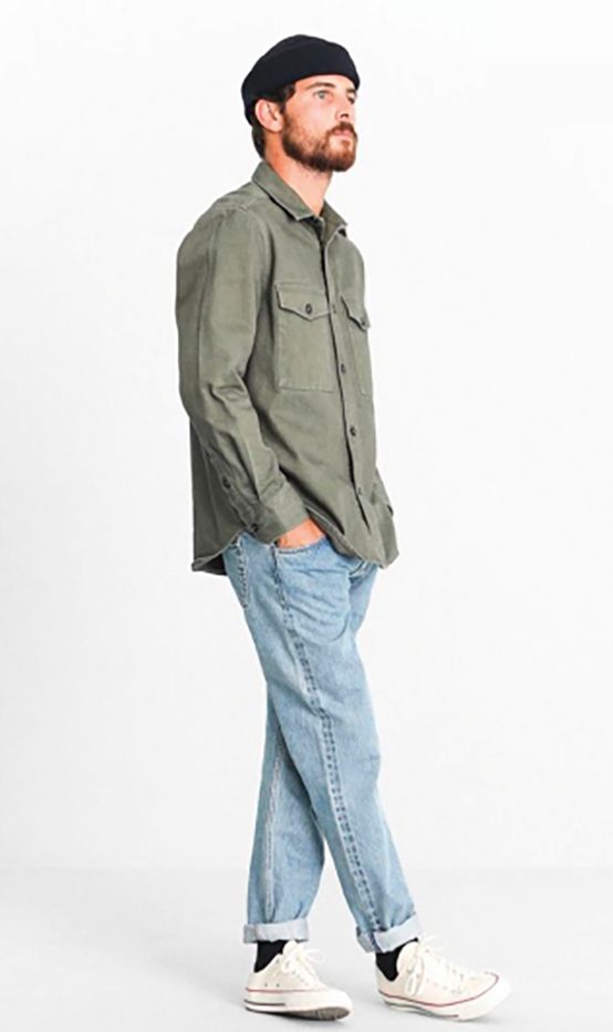 Modelo con sobrecamisa verde oliva y vaquero claro sobre blanco